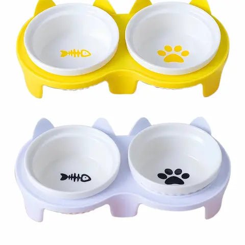 Vue de deux sets de gamelles surélevées en céramique sur support (jaune et blanc) pour l'alimentation des chats