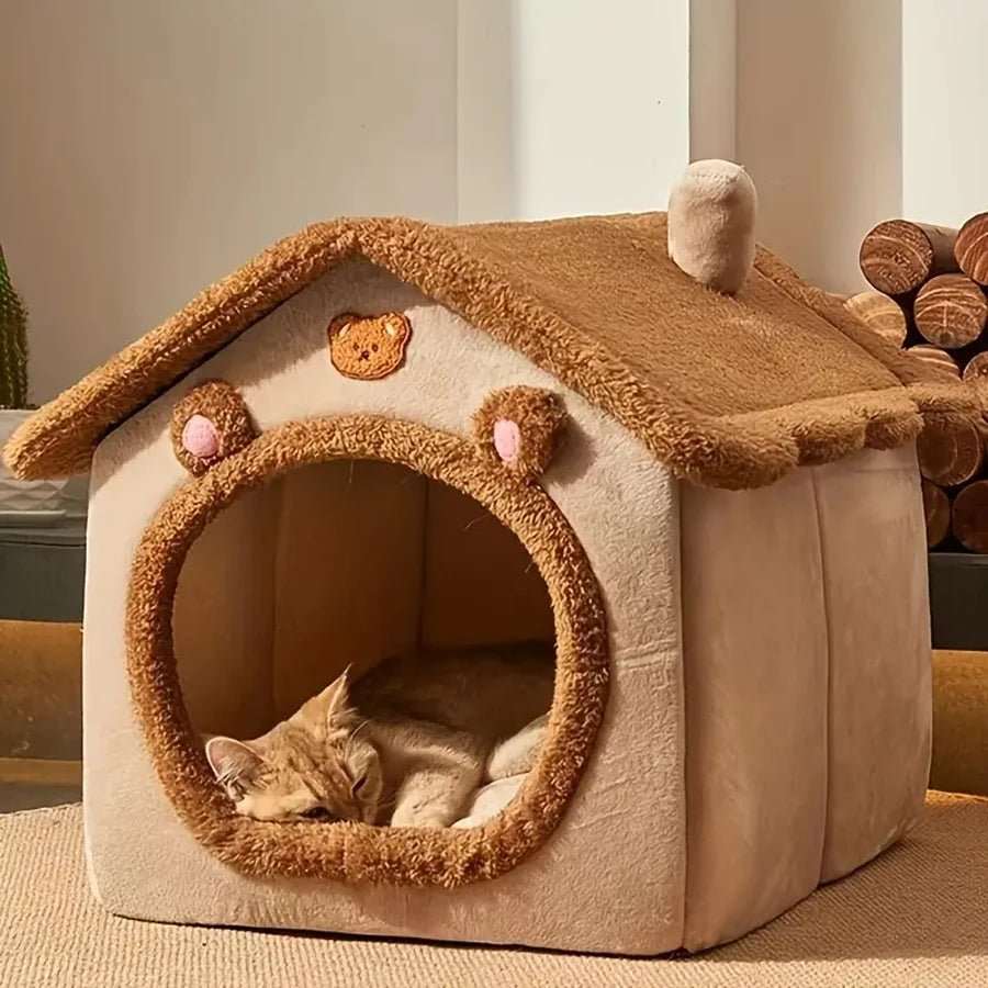 Chat roux dans une maison chat douillette d'intérieur en forme d'ours.