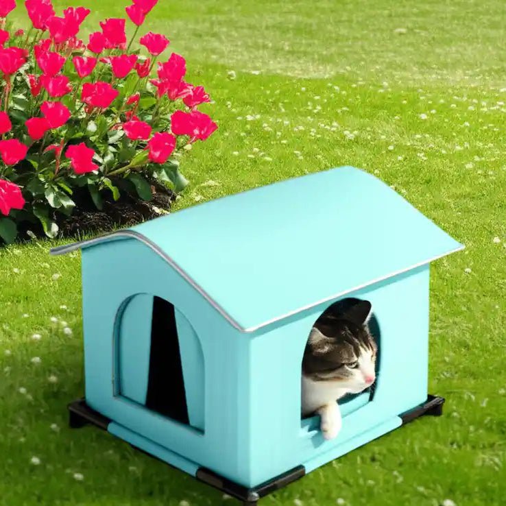 La maisonnette pour chat est placée dans un jardin, avec des fleurs en arrière-plan, illustrant sa polyvalence.