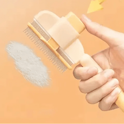 Brosse démêlante pour chat avec système auto-nettoyant activé, les poils s'éjectent en un bloc après pression sur le bouton