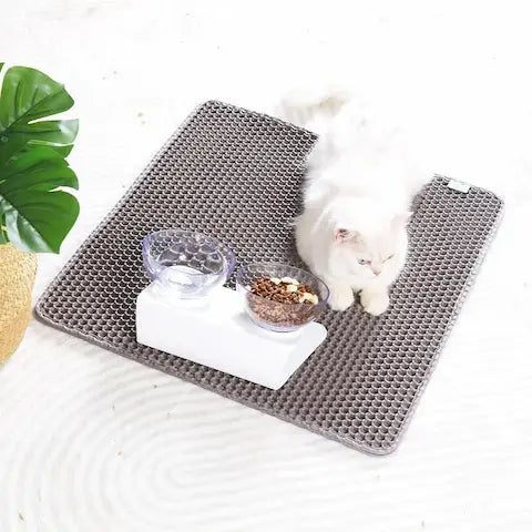Chat blanc allongé confortablement sur un tapis anti-litière double couche, l'utilisant comme couchage