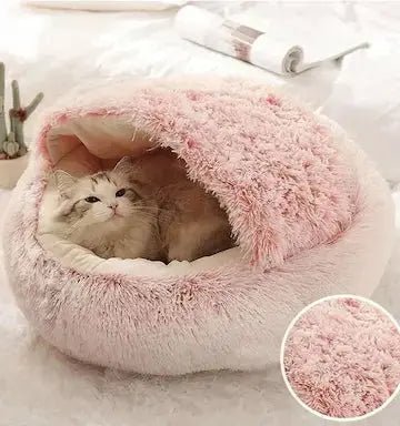 Chat blotti dans lit rond rose- cocon apaisant pour félin anxieux